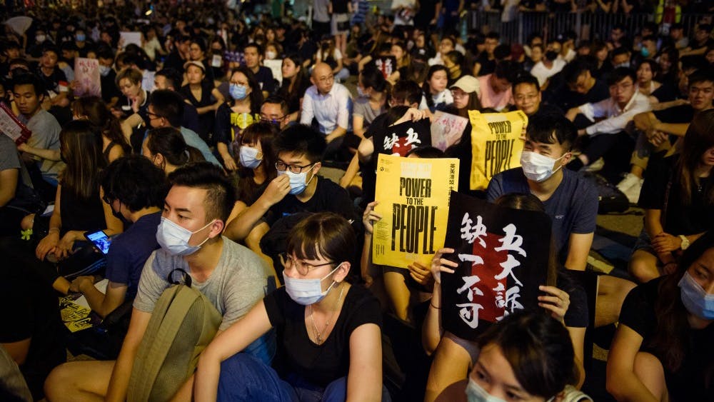Participants hold up signs with the inscription, &quot;Power to the People,&quot; on Aug. 16 at a protest rally in front of the Chater Garden in the Central District in Hong Kong. In recent weeks, authorities have ramped up pressure on protesters in Hong Kong, calling their demonstrations &quot;terrorism&quot; and hinting at Chinese military intervention.