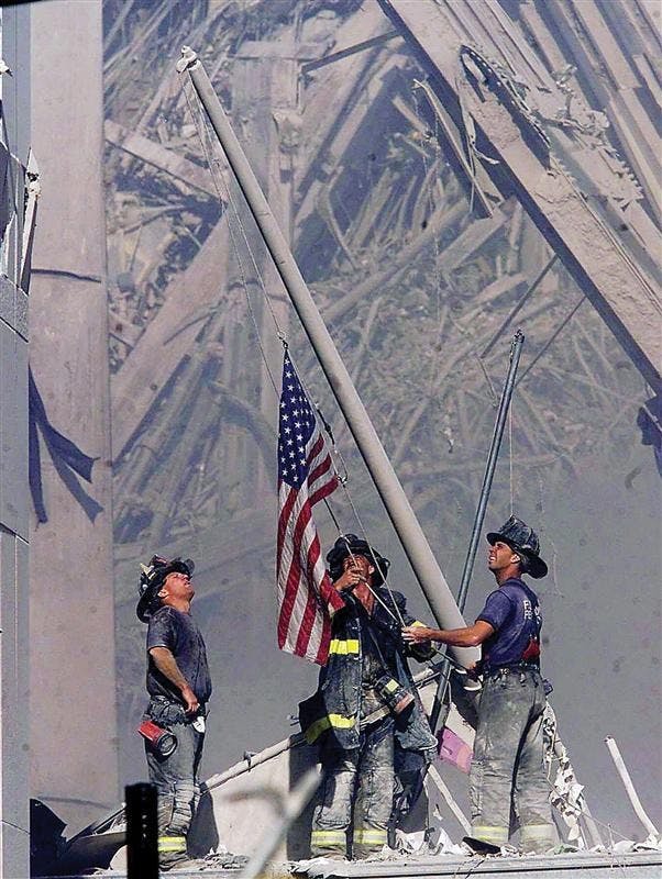 Firefighters raise a flag late in the afternoon on Tuesday, Sept. 11, 2001, in the wreckage of the World Trade Center towers in New York. In the most devastating terrorist onslaught ever waged against the United States, knife-wielding hijackers crashed two airliners into the World Trade Center toppling its twin 110-story towers.
