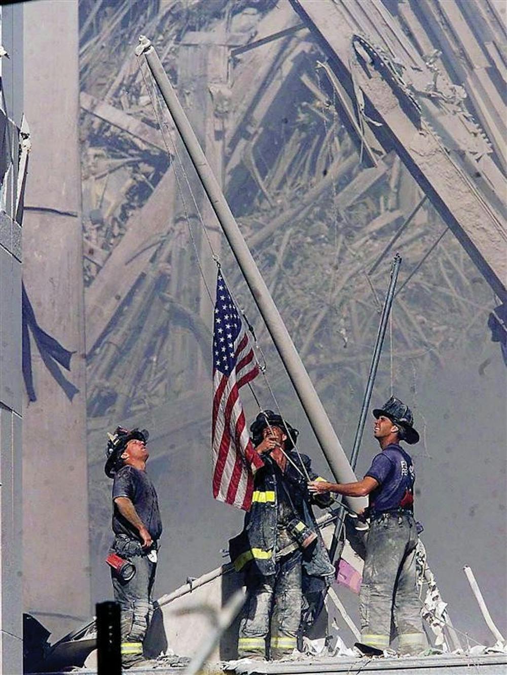 Firefighters raise a flag late in the afternoon on Tuesday, Sept. 11, 2001, in the wreckage of the World Trade Center towers in New York. In the most devastating terrorist onslaught ever waged against the United States, knife-wielding hijackers crashed two airliners into the World Trade Center toppling its twin 110-story towers.
