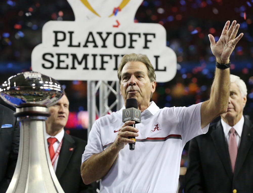 Alabama head Coach Nick Saban is presented the trophy after a 24-7 victory against Washington in the Peach Bowl at the Georgia Dome in Atlanta on Saturday, Dec. 31, 2016. Saban won his sixth national championship against Georgia Monday night.&nbsp;