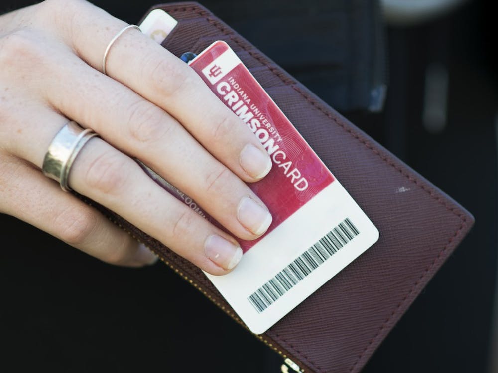 A Crimson Card is held with a wallet. The Crimson Card system will undergo a maintenance upgrade from Jan. 4 to 7, according to an University Information Technology Services press release. 