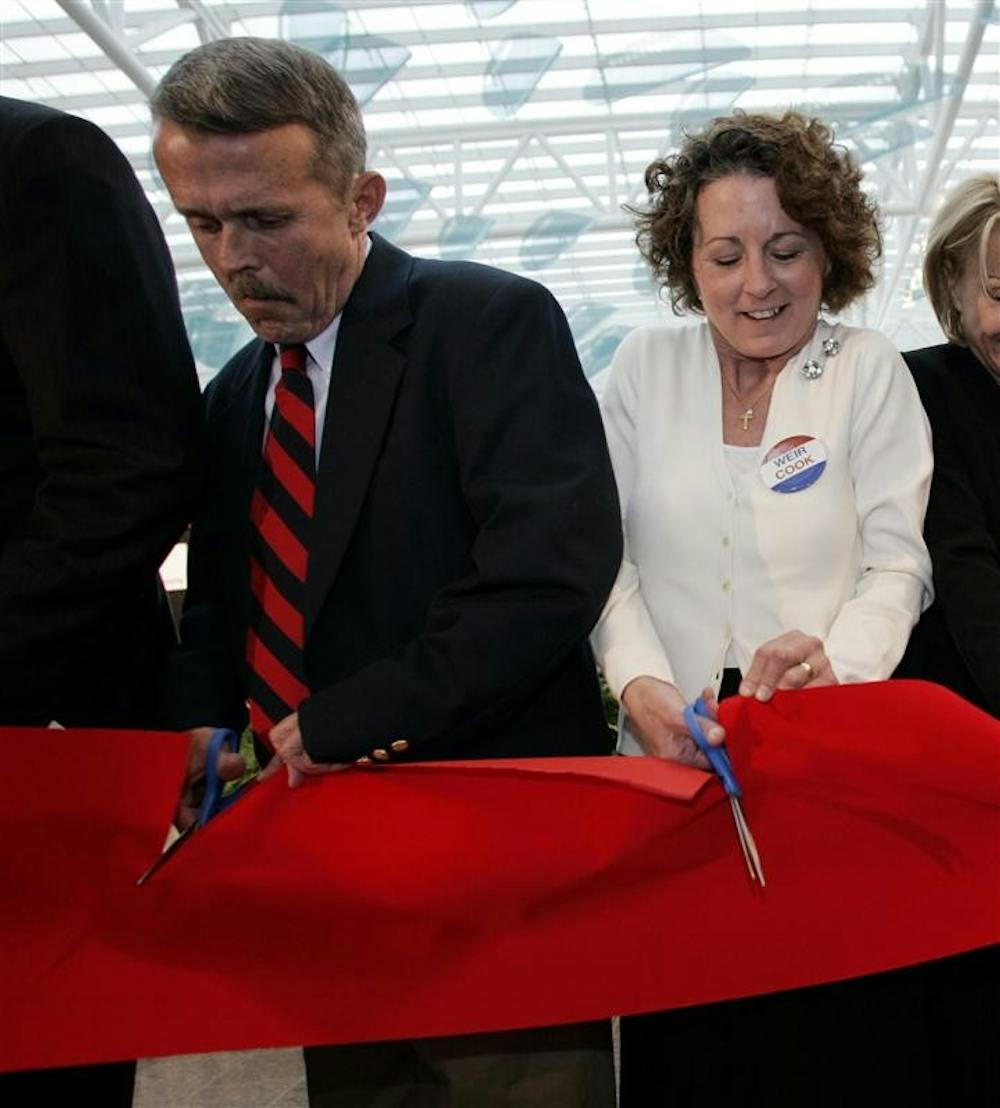 Harvey Weir Cook III, left, of Columbus, Ohio, and Margaret Locke, of Ligonier, Ind., granchildren of World War I flying ace Harvey Weir Cook, cut the ribbon during the grand opening of the new Col. H. Weir Cook Terminal Building on Tuesday at the Indianapolis International Airport in Indianapolis. The new terminal was to receive its first arriving passengers later Tuesday. 