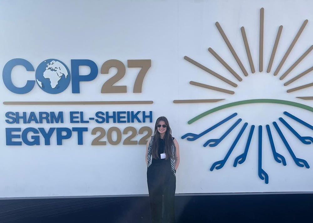 <p>IU student Abby Potter stands against a sign for the 27th Conference of the Parties in Sharm El-Sheikh, Egypt. IU students attended the summit as part of Professor Jessica O’Reilly’s international climate government course.</p>