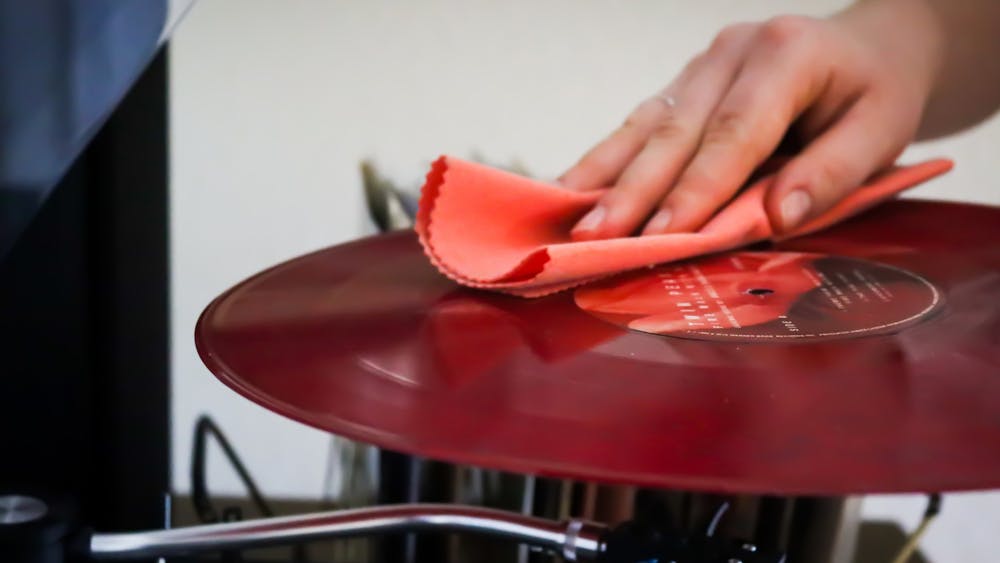 周日，一名印第安纳大学的学生在她的公寓里播放一张黑胶唱片前清理它。唱片公司员工艾米丽·莫里斯建议黑胶唱片的拥有者在使用前要清理唱片。