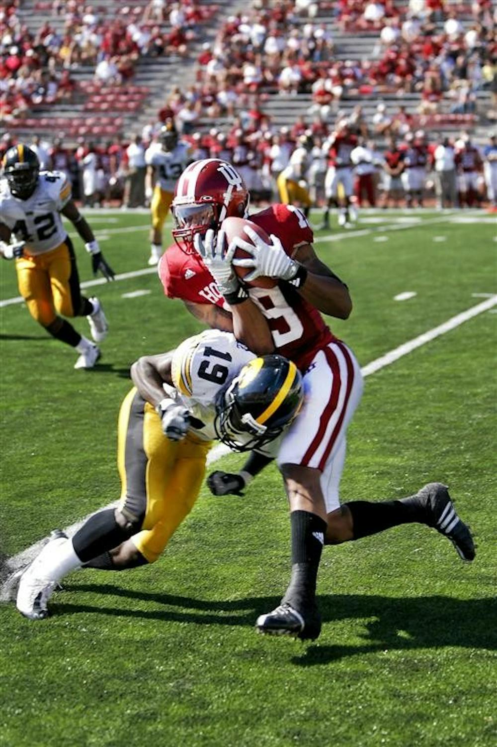Senior wide receiver Brandon Walker-Roby takes a hit from Iowa defensive back Amari Spievey in front of a thinning Memorial Stadium crowd during the Hoosiers 45-9 loss to Iowa Saturday afternoon at Memorial Stadium.