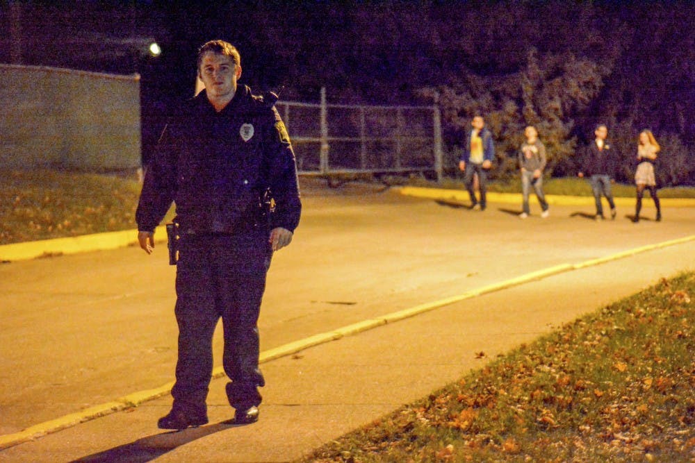 After making sure a group of freshmen who seem drunk and walked toward East Law Lane jiggly, Lan Kalb, part-time officer with IUPD, keeps watch outside of McNutt Quad to help make sure freshmen stay safe. Kalb said student officers guard every dorm from 9 p.m. to 3 a.m. every Friday and Saturday night. Almost every night, Kalb sees freshmen passing out from too much alcohol consumption.