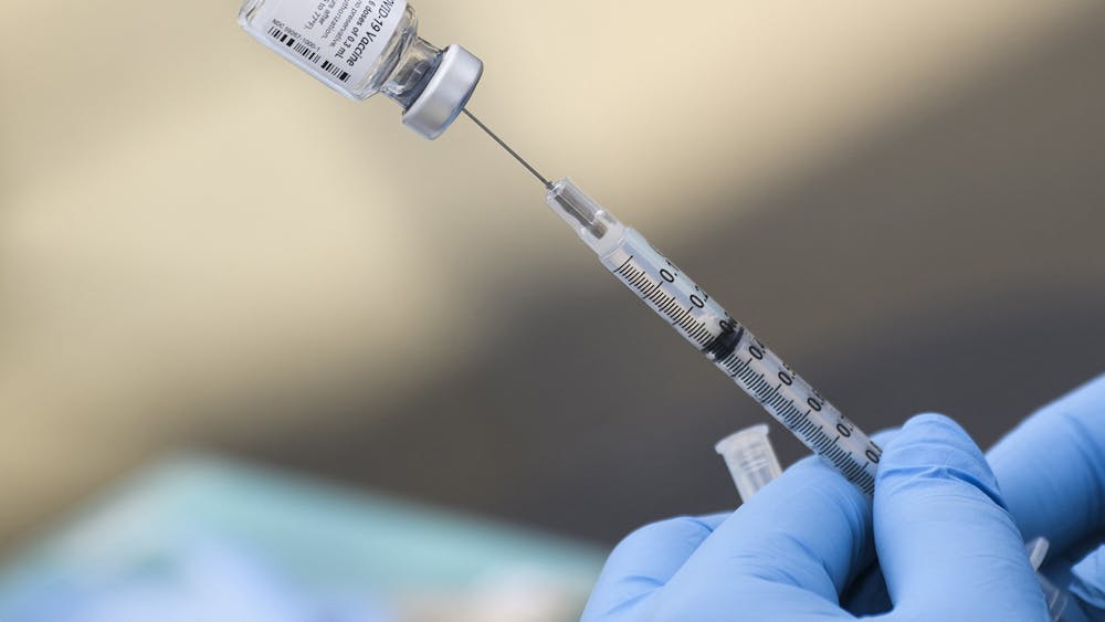 A syringe is filled with a dose of the Pfizer COVID-19 vaccine Aug. 7, 2021, at a mobile vaccination clinic in Los Angeles. Monroe County reported five COVID-19 cases for the week March 6-12.   
