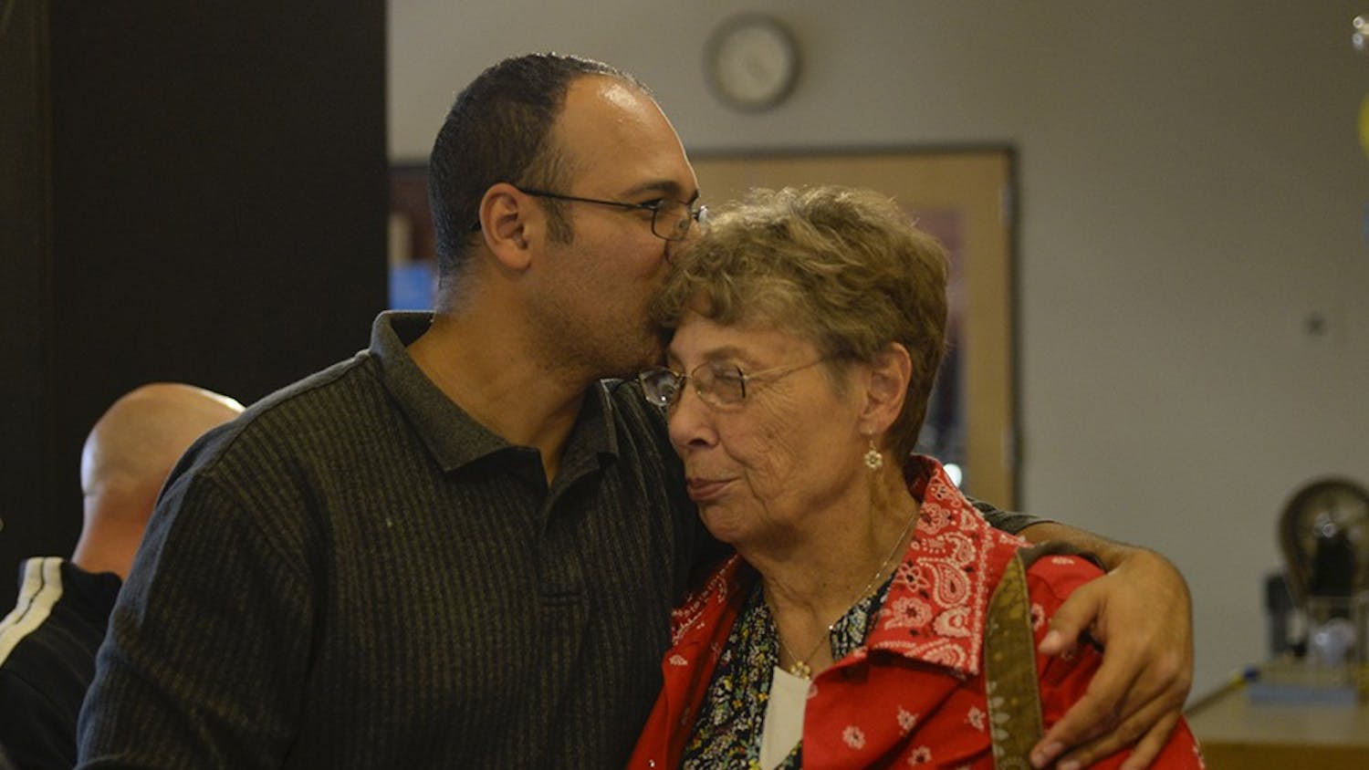 Macabee kisses his mother on the forehead at his son's, Jaxon, birthday party. The support that Macabee has had from his family has been monumental in his struggle to balance his busy life.