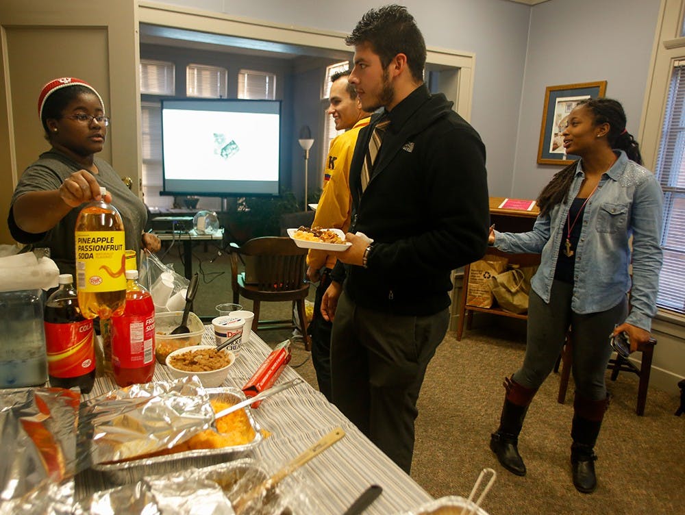 People eat different ethnic foods Friday at La Casa Latino Cultural Center. Members of Sigma Lambda Gamma made different cultural dishes. 