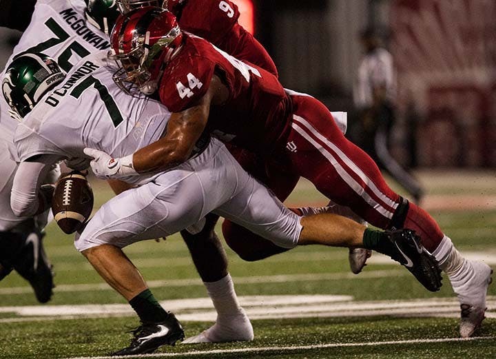 Junior linebacker Marcus Oliver, 44, tackles Michgian State quaterback Tyler O'Connor during the first quarter of play.