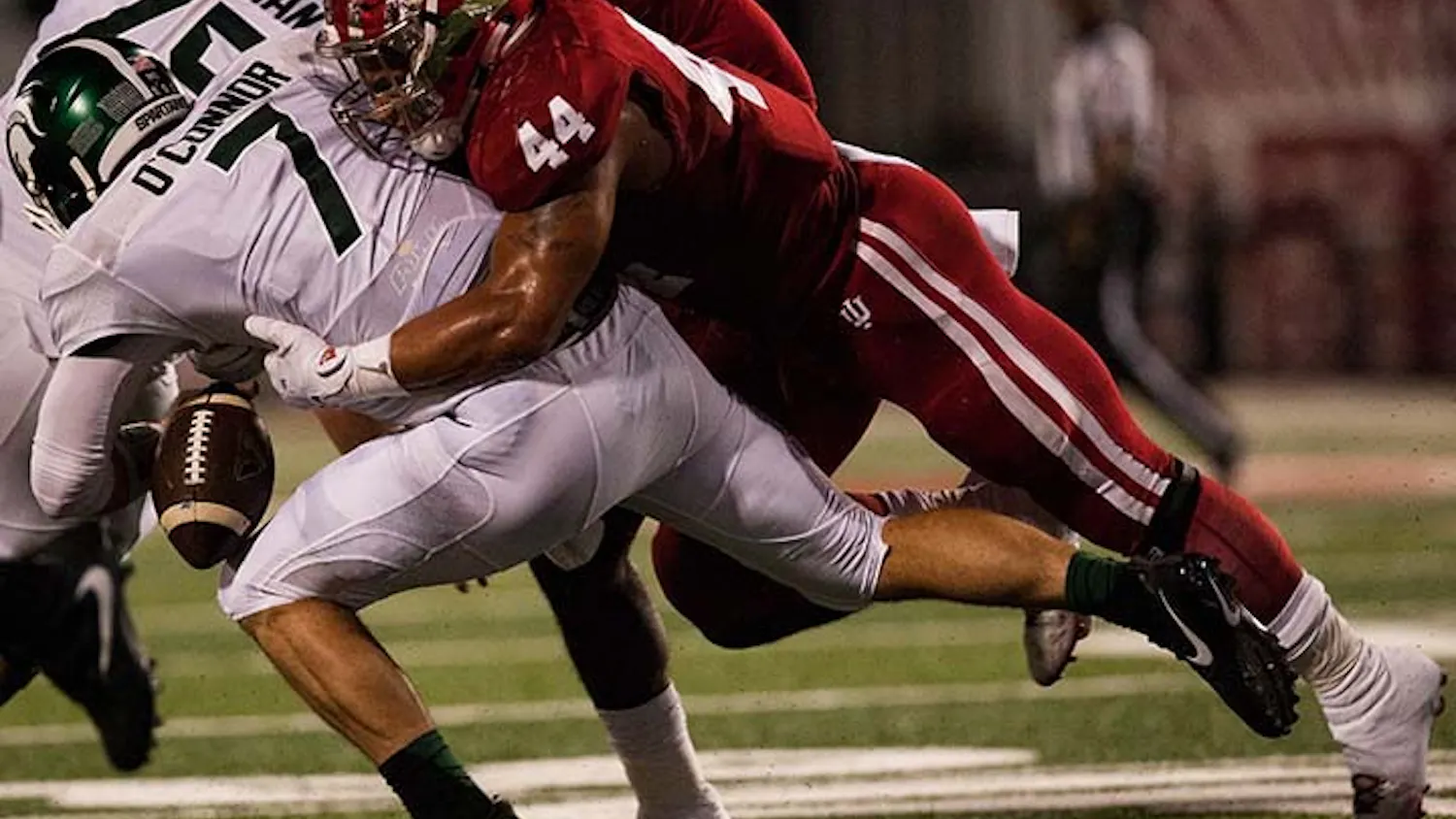 Junior linebacker Marcus Oliver, 44, tackles Michgian State quaterback Tyler O'Connor during the first quarter of play.