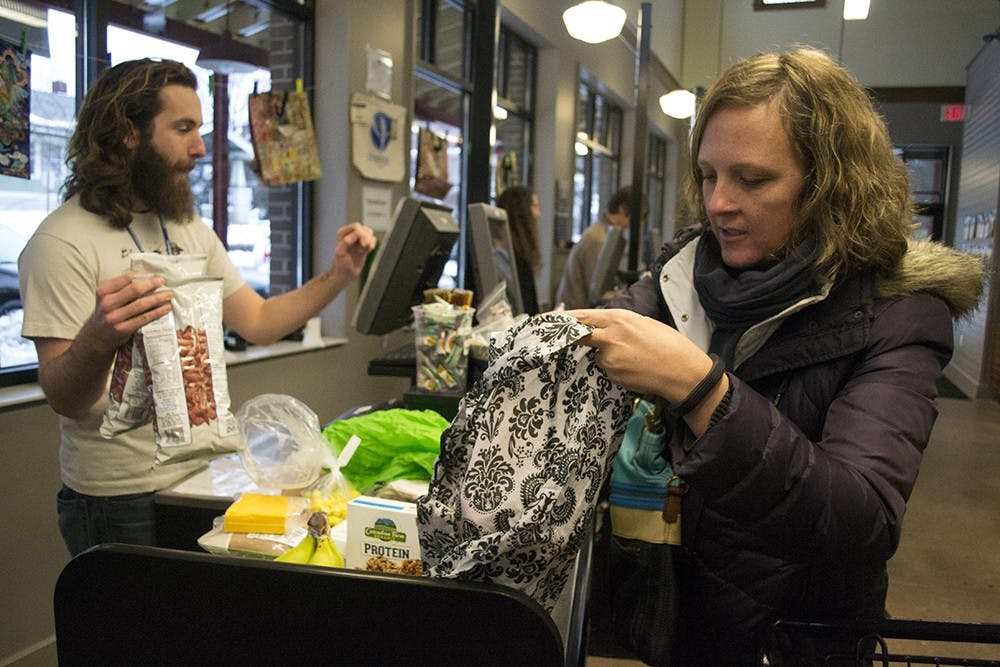 Bloomington resident Genevieve Pritchard bags her groceries at Bloomingfoods Elm Heights on Tuesday. Pritchard said she was surprised to hear that using a resusable bag reportedly influences shoppers' decisions about buying healthy foods. "Maybe at a place like Kroger or Marsh," she said.