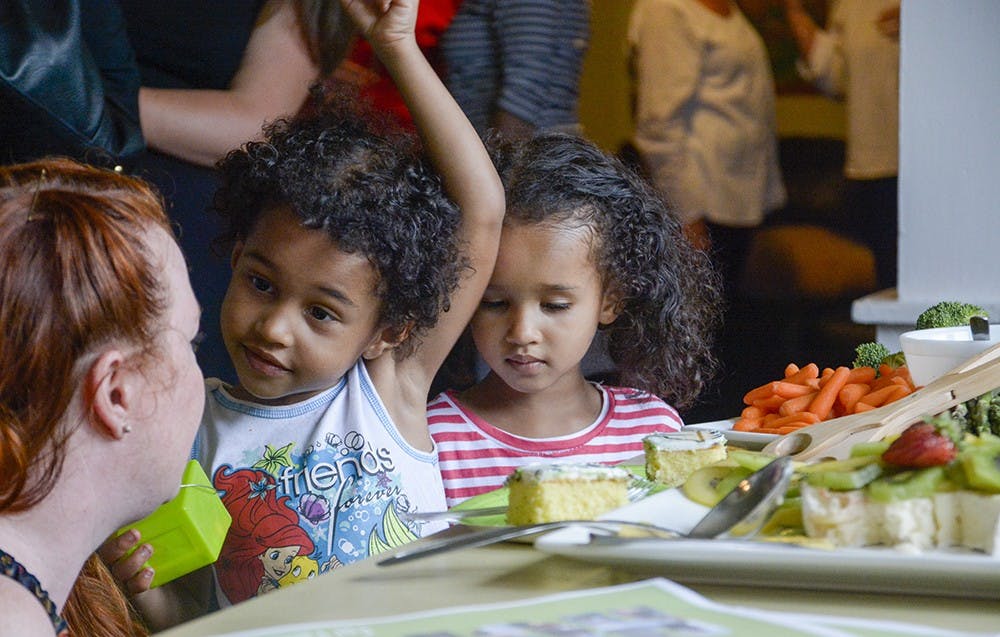 Shanel Couts, right, and Abigail Couts talks to participants in front of the "Birthday Cake" on Thursday evening during the New Hope community shelter's 5th birthday at the shelter. 
