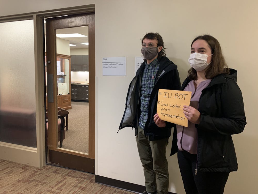 <p>Indiana Graduate Workers Coalition-United Electrical Workers members Pat Wall and Rachel Epplin stand outside the Office of the Board of Trustees on Dec. 10, 2021, at Franklin Hall. A majority of IU’s graduate workers submitted union cards petitioning for a union vote.</p>