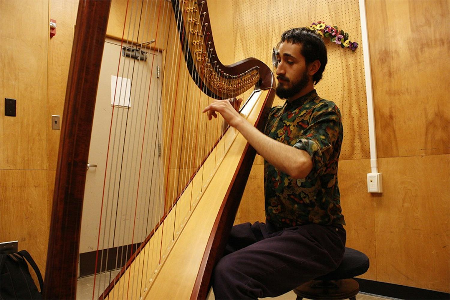In a practice room at the Music Building Addition, first-year harp major Rodrigo García Castrejón improvises for a warm-up before practicing.  