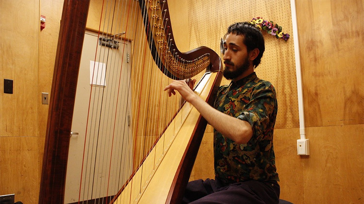 In a practice room at the Music Building Addition, first-year harp major Rodrigo García Castrejón improvises for a warm-up before practicing.  