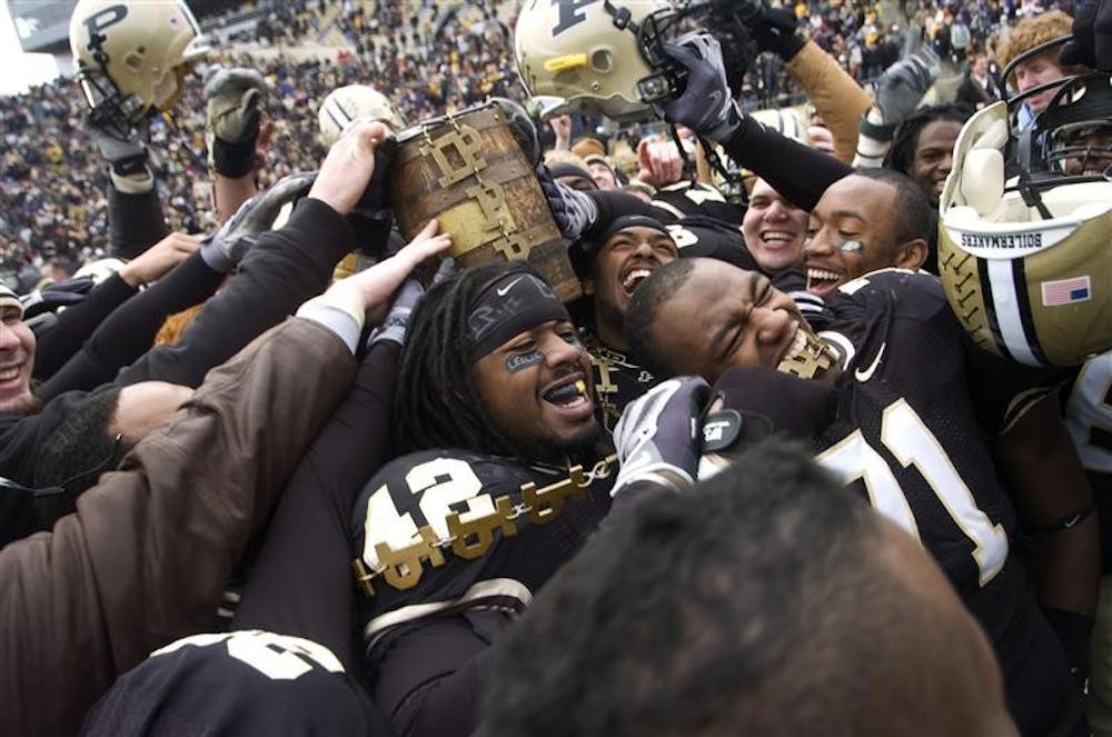 Purdue football players celebrate with the Old Oaken Bucket in hand after defeating Indiana 62-10 Saturday in West Lafayette.  Purdue's victory marked head coach Joe Tiller's last game after coaching the Boilermakers for 12 years.