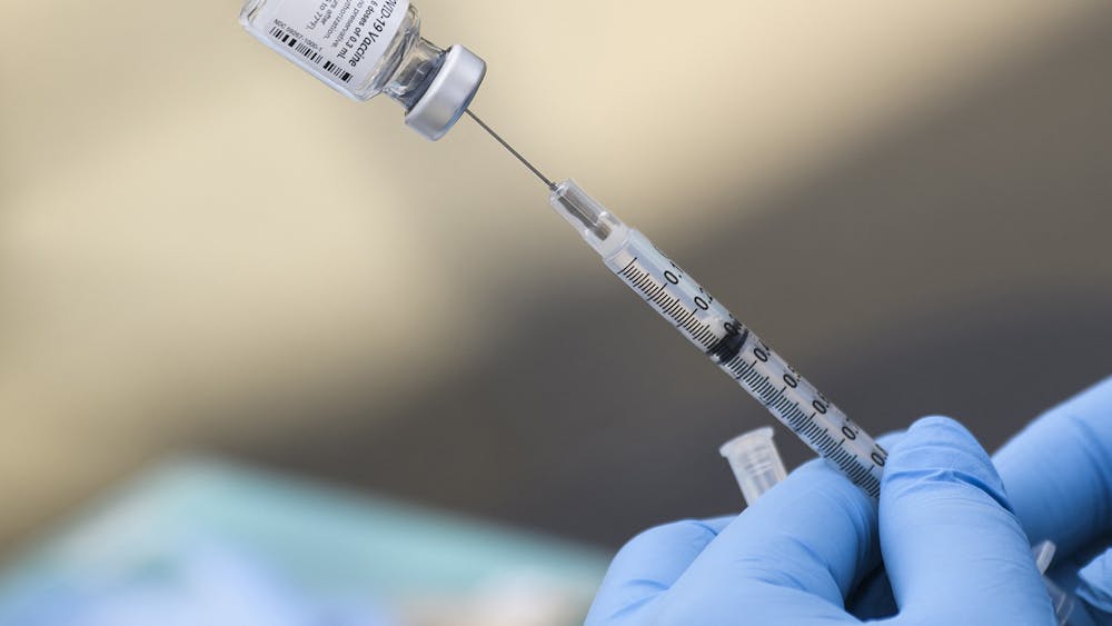 A syringe is filled with a dose of the Pfizer COVID-19 vaccine Aug. 7, 2021, at a mobile vaccination clinic in Los Angeles. There will be COVID-19 bivalent booster clinic for students at the Student Health Center Dec. 5, 6 and 7 by appointment only.