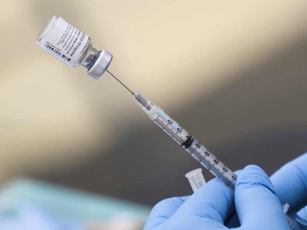 A syringe is filled with a dose of the Pfizer COVID-19 vaccine Aug. 7, 2021, at a mobile vaccination clinic in Los Angeles. There will be COVID-19 bivalent booster clinic for students at the Student Health Center Dec. 5, 6 and 7 by appointment only.