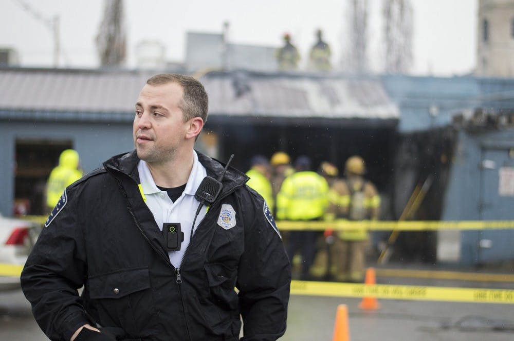 Bloomington Police Officer Morgan Berns wears his body cam as he stands in front of Village Deli after their kitchen caught fire last January. 