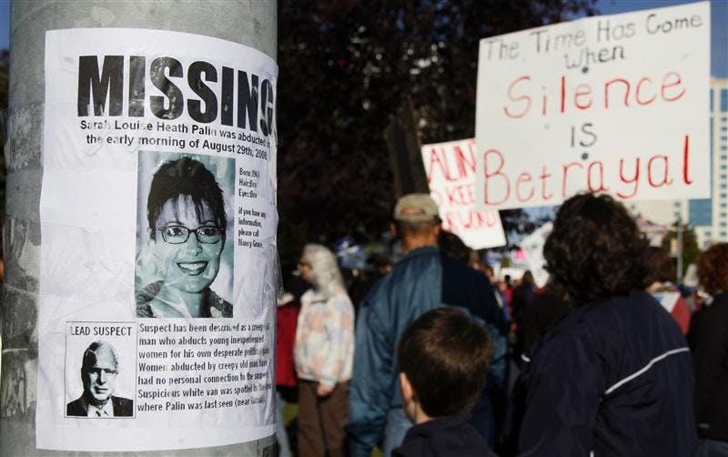 A missing sign with Alaska Gov. Sarah Palin's picture is taped on a light post as protesters hold signs on Sept. 27 at a Hold Palin Accountable rally organized by Alaskans For Truth in Anchorage. Hundreds of people showed up to demand Palin uphold her promise to cooperate with the state legislature's investigation into her firing of Public Safety Commissioner Walt Monegan. On Friday, a panel committee found Palin unlawfully abused her authority when she fired Monegan.