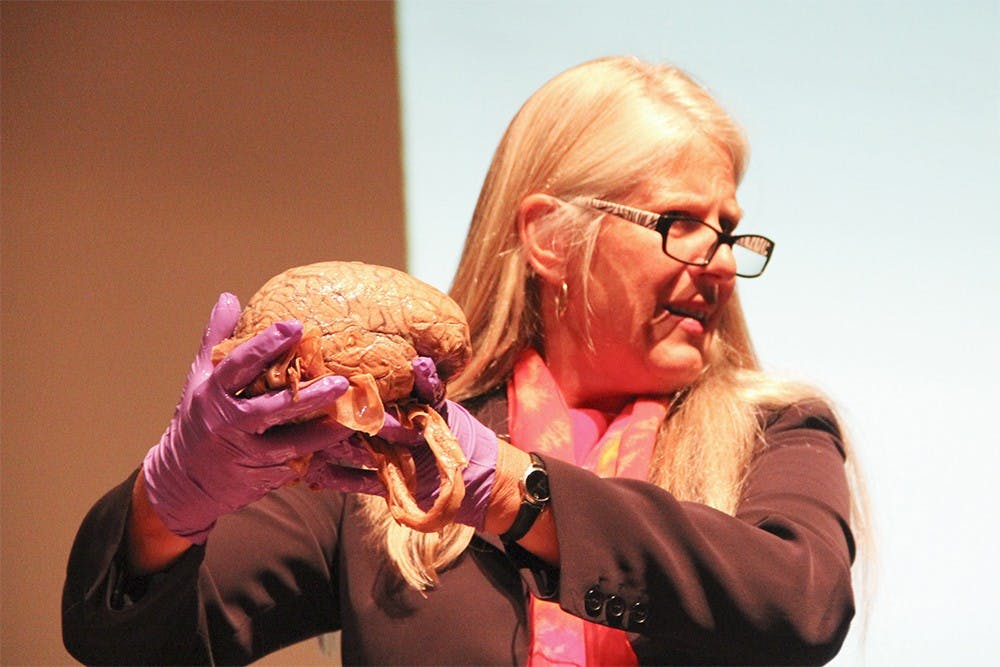 Dr. Jill Bolte Taylor shows a human brain to the audience during her lecture, "Understanding the (Beautiful) Teenage Brain," at Bloomington High School North on Monday.