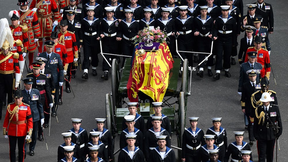 Royal Navy sailors walk ahead and behind the coffin of Queen Elizabeth II, draped in the Royal Standard, as it travels on the State Gun Carriage of the Royal Navy followed by  members of the Royal family, from Westminster Abbey to Wellington Arch in London on Sept. 19, 2022, after the State Funeral Service.