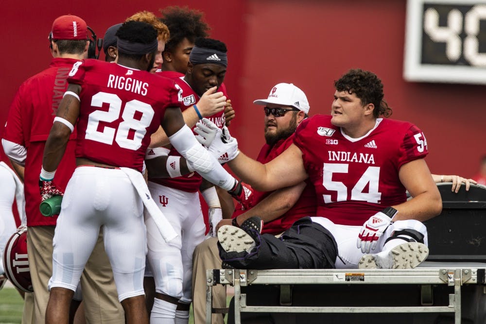 IU’s football team high-fives senior offensive lineman Coy Cronk on Sept. 21 at Memorial Stadium. Cronk was injured during the first quarter against University of Connecticut.
