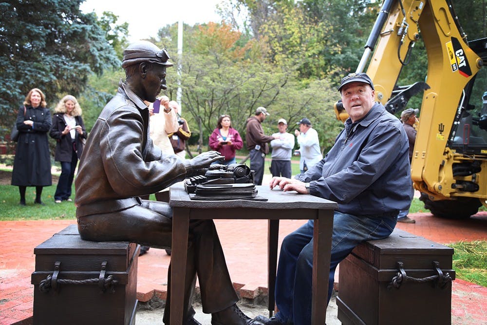 Sculptor Tuck Langland sits with the sculpture of Ernie Pyle he created for The Media School on Thursday outside Franklin Hall. There will be a dedication of the Ernie Pyle sculpture on Oct. 17, along with a formal inauguration of The Media School. 