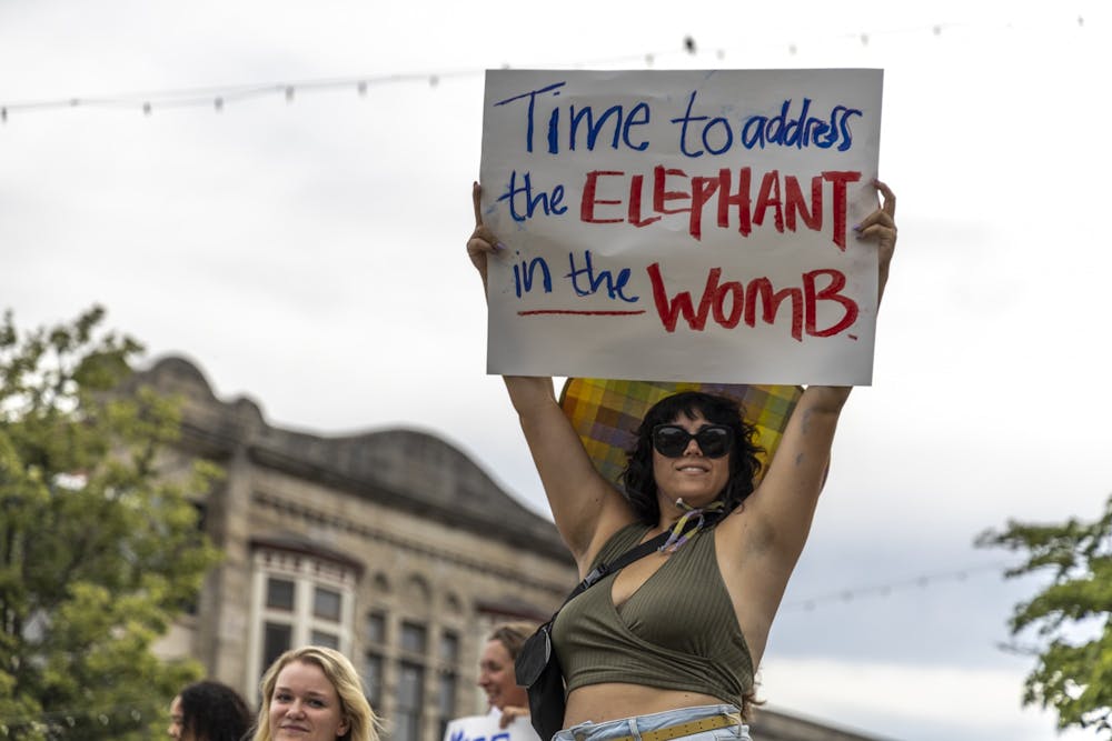 <p>Heather Farmer holds a sign that says &quot;Time to address the elephant in the womb&quot; above her head outside the Monroe County Courthouse on June 24, 2022, during a protest in support of reproductive rights. &quot;Reproductive choice matters,&quot; Farmer said.</p>