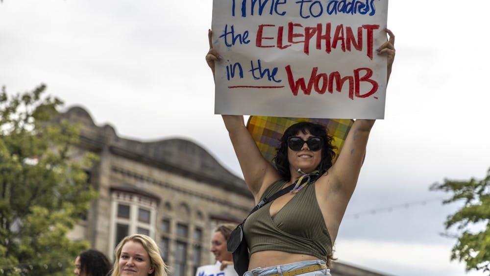 Heather Farmer holds a sign that says &quot;Time to address the elephant in the womb&quot; above her head outside the Monroe County Courthouse on June 24, 2022, during a protest in support of reproductive rights. &quot;Reproductive choice matters,&quot; Farmer said.