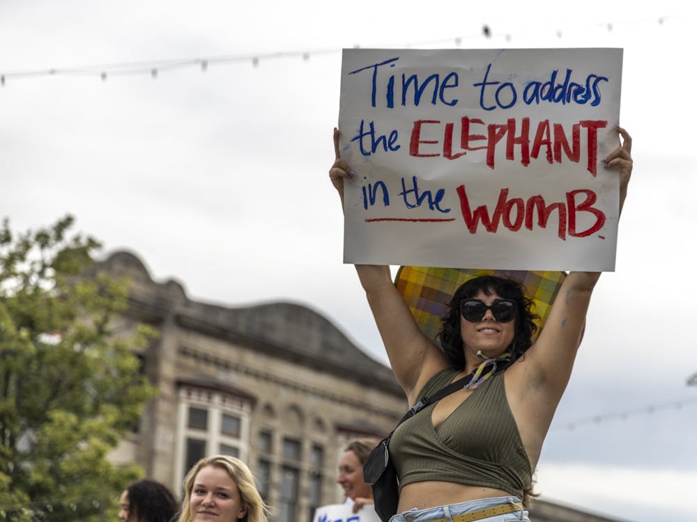 Heather Farmer holds a sign that says &quot;Time to address the elephant in the womb&quot; above her head outside the Monroe County Courthouse on June 24, 2022, during a protest in support of reproductive rights. &quot;Reproductive choice matters,&quot; Farmer said.