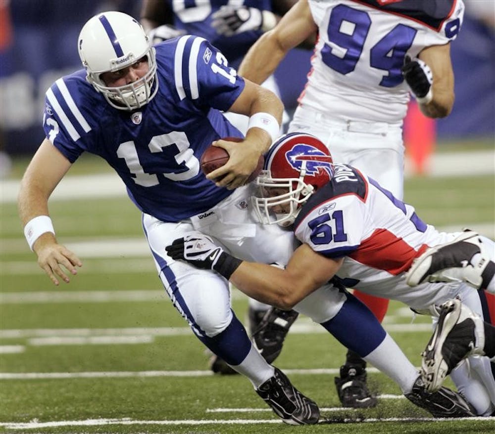 Indianapolis Colts quarterback Jared Lorenzen (13) is tackled by Buffalo Bills linebacker Paul Posluszny (51) during the first quarter of a preseason NFL football game Sunday in Indianapolis. The game is the Colts' first in the new Lucas Oil Stadium.