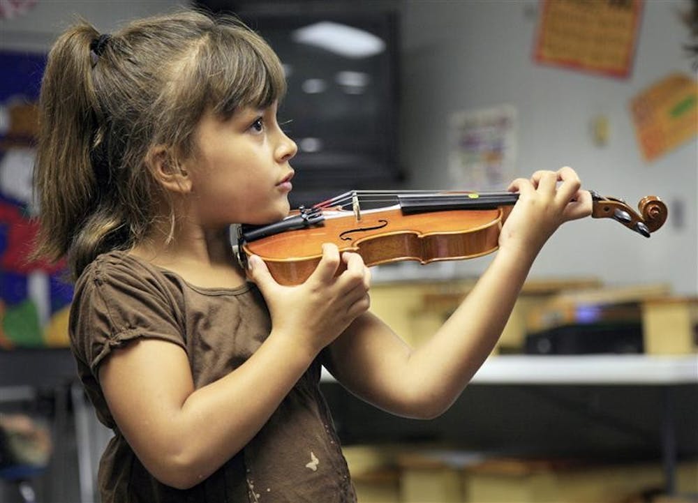 Neveah Stevens practices holding her violin.