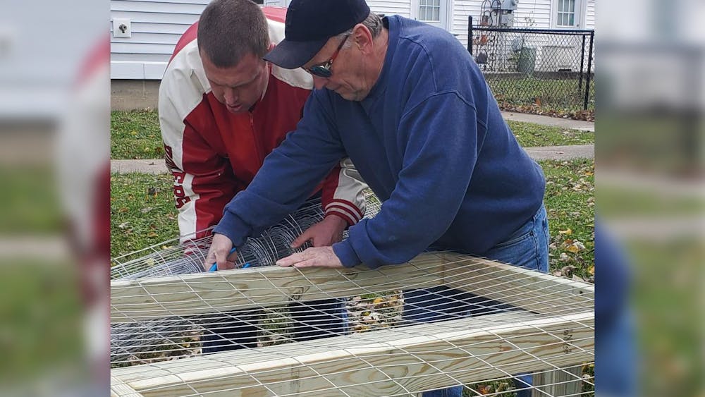 Casey Mangum and his father Garrett work on constructing the LIFEdesigns community garden on South Covey Lane. Casey Mangum is an active LIFEDesigns client and Garrett has a background in sustainable construction. 