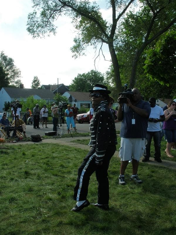 Antonio Wilson, dressed in full Jackson stage garb, excites the crowd of Jackson fans on the front lawn of Jackson's boyhood home in Gary.