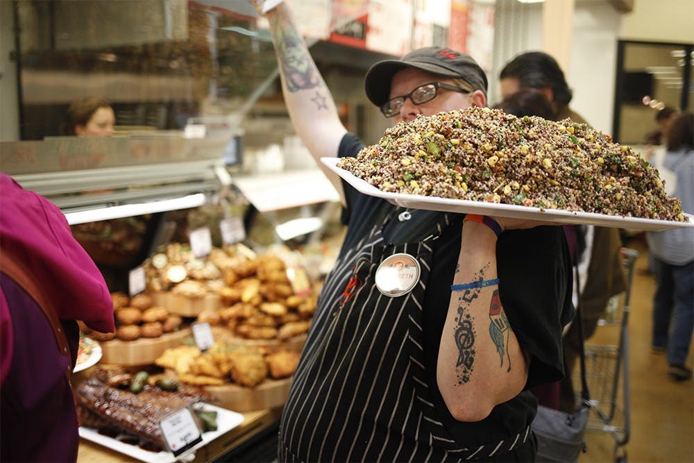 Elizabeth Cox prepares to put a platter inside a display case in the deli department Wednesday at Lucky's Market.