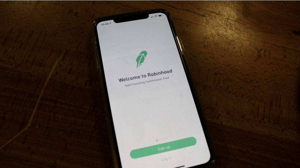 A phone displays the sign-up and login page for RobinHood. 