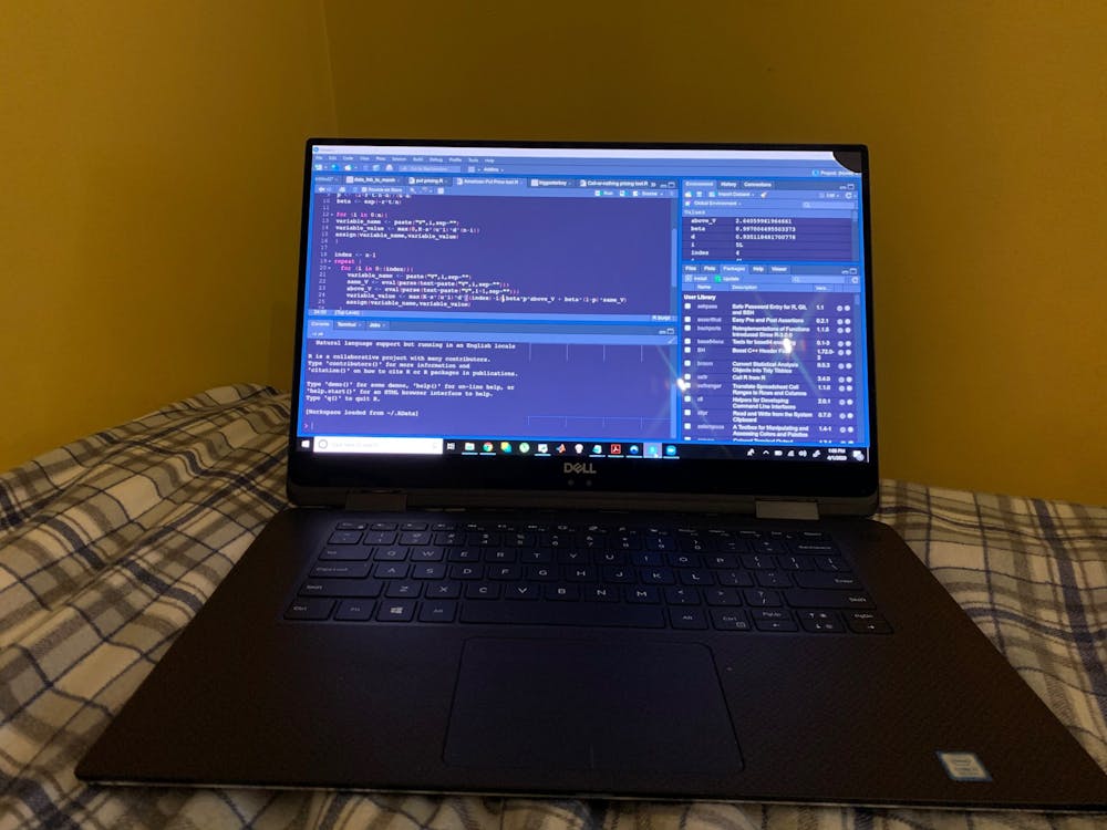<p>A student&#x27;s computer showing coding practices sits on a bed. </p>