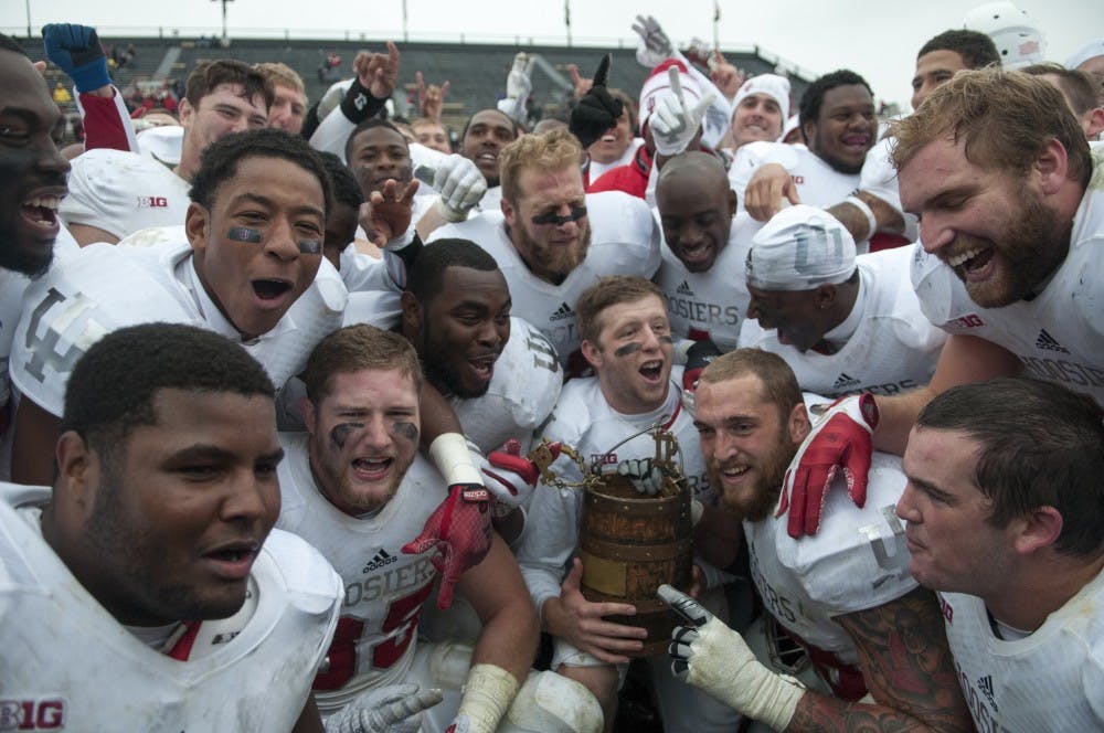 Senior quarterback Nate Sudfeld holds the Oaken Bucket and members of the football team celebrate after beating Purdue, 54-36 on Saturday at Ross-Ade Stadium. 