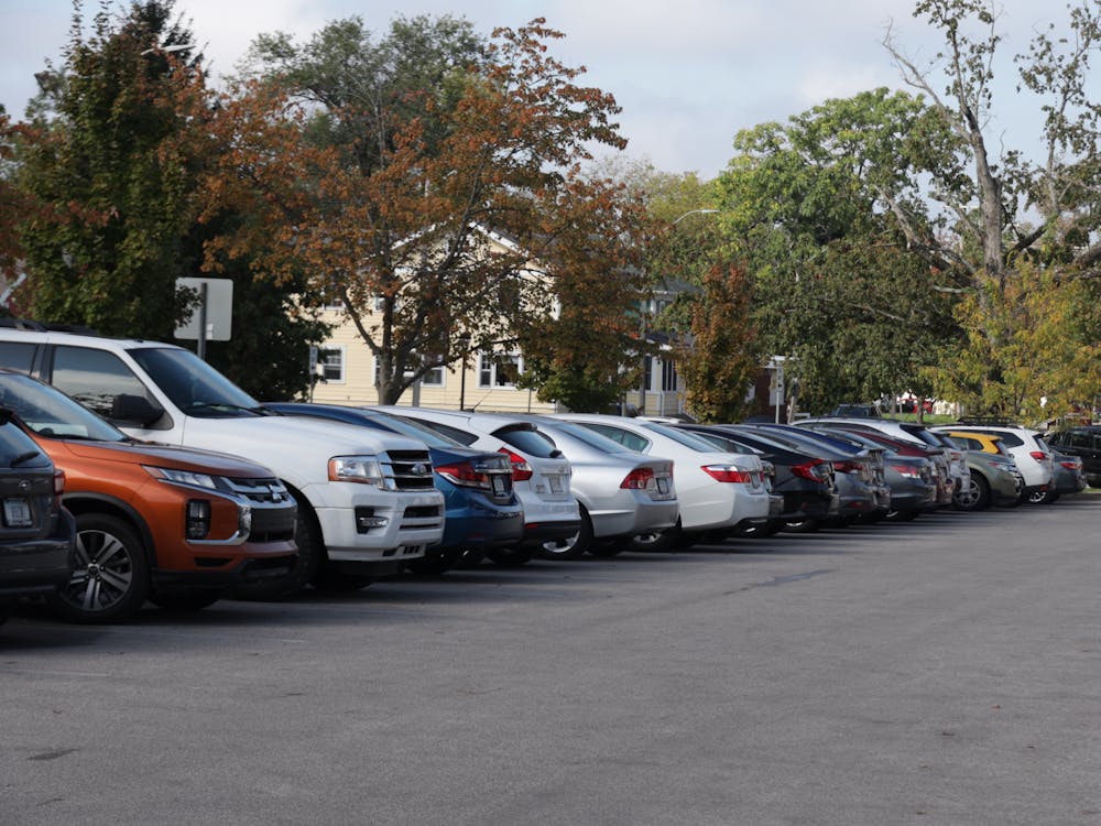 Cars are seen parked Oct. 5, 2021, in the parking lot on the corner of Atwater Ave. and S. Woodlawn Ave. IU students have begun to get involved with local government to fight against predatory towing practices in Bloomington.