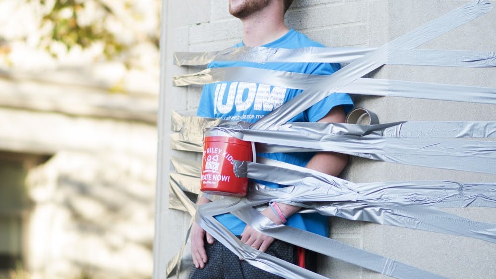Isaac Peasley, a junior, tapes himself to the Sample Gates for IU Dance Marathon's Day of Hope. Peasely, who has participated in six dance marathons, said he started getting involved with the event when a close friend received medical treatment from Riley Hospital for Children in Indianapolis.&nbsp;