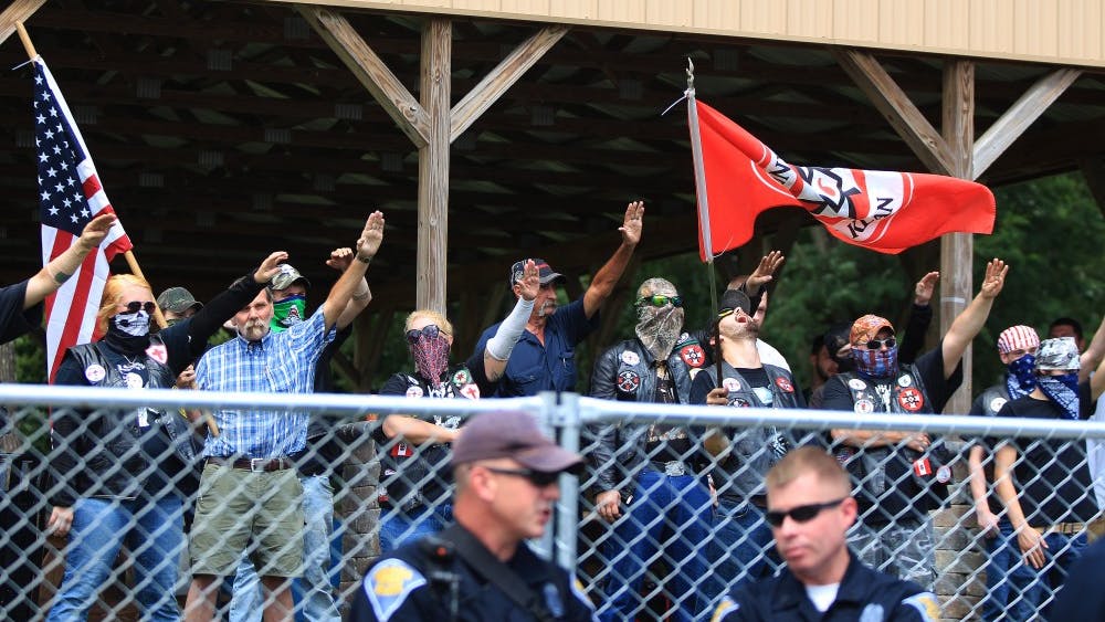 Members of the Ku Klux Klan in Madison, Indiana, raise their hands and shout, “White power.” People on the opposite side of the fence shouted several things back in response, like "Black lives matter."&nbsp;