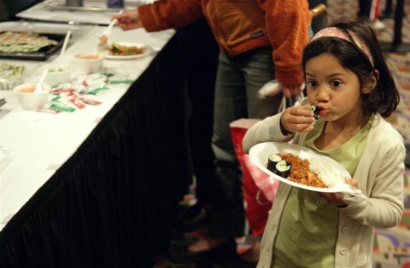 Krisna Wilson enjoys a piece of sushi during Taste of Asia Sunday afternoon at the IU Auditorium. Taste of Asia featured food from local restaurants in Bloomington and performances by various groups from IU.