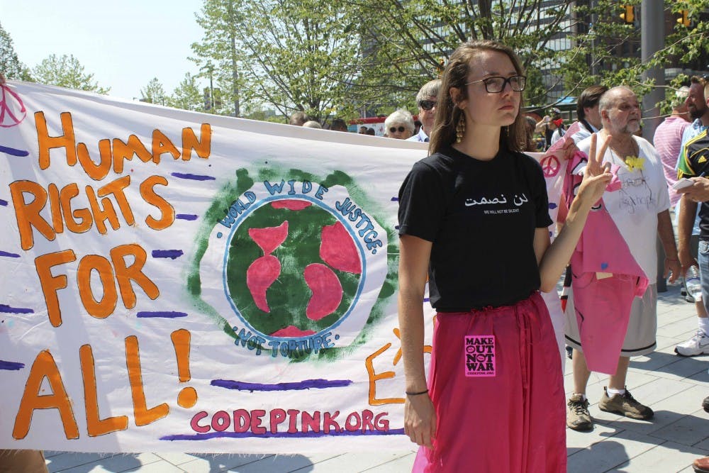 Code Pink activist Chelsea Byers stands in Public Square in Cleveland, OH, sporting a "Make Out Not War" sticker on her pink pants. The group opposes the U.S. war on Iraq and often uses satirical and theatrical tactics to deliver its message for peace.