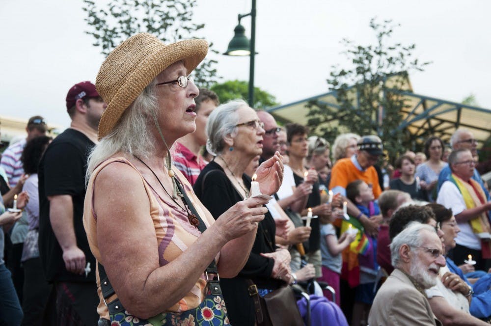 People light up their candles for the victems of the Orlando tragedy Tuesday evening at the Bloomington City Hall.