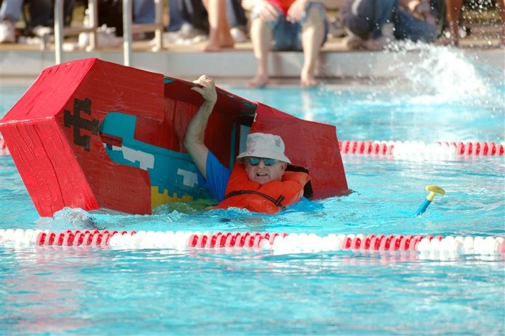 Dean McKaig holds on to the last moment after his boat capsized in the Cardboard Regatta on Friday at the Outdoor Pool. The 8th annual regatta featured the dean's challenge race featuring Deans Dick McKaig, Bob Goodman and Stephen Watt.
