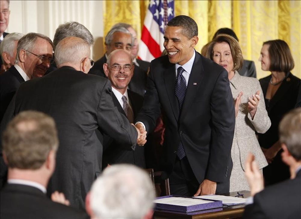 President Barack Obama shakes hands with Rep. John Dingell, D-Mich., after signing into law the State Children's Health Insurance Program, Wednesday in the East Room of the White House in Washington.