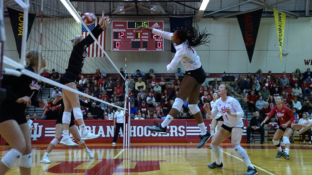 Then-junior middle blocker Deyshia Lofton spikes the ball for a kill against two University of Nebraska — Lincoln defenders on Nov. 17 in University Gym. IU’s nonconference schedule will begin this weekend at the Indiana Invitational, with four matches being played between Friday and Saturday at Wilkinson Hall. 
