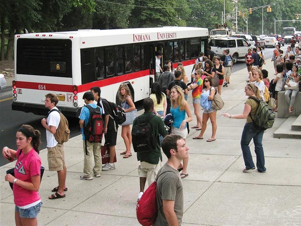 Students wait in line for campus bus services Wednesday afternoon at Wells Library.